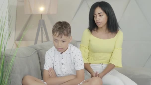 Az afro-amerikai anya és fia konfliktusa otthon. Egy elégedetlen nő arcképe, aki szidja a kisfiút. A gyerek rosszul viselkedik, és a szülő kiabál vele. Családi veszekedés odabent.. — Stock videók