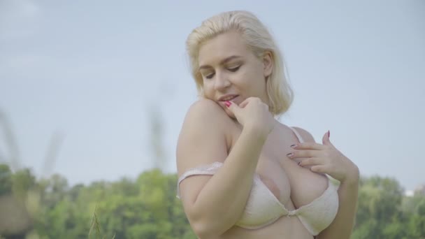 Overweight lady in lace bra putting down strap and looking at camera. Portrait of seductive plus size Caucasian woman flirting at camera on sunny summer day outdoors. Flirt and sensuality. — Stock Video