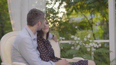 Romantik bir köşkte kucaklaşan ve konuşan mutlu bir çift. Olumlu gülümseyen erkek ve kadının yaz günü çıktıkları portre. İnsanları gizleyen beyaz perde.