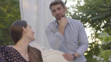 Sevgi dolu bir kadına bakan ve konuşan mutlu yakışıklı bir adam. Yazın açık havada genç ve güzel bir esmer kızla çıkan neşeli orta yaşlı beyaz erkek arkadaş portresi..