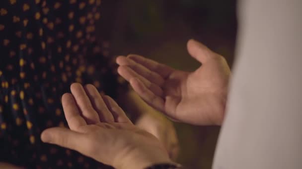 Close-up of male Caucasian hands taking palms of young woman. Unrecognizable couple expressing love outdoors on summer night. Bonding and love concept. — Stock Video