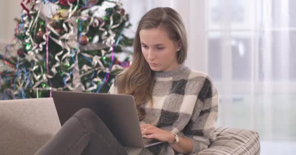 Portrét mladé ženy používající notebook o vánočních víkendech. Krásná brunetka běloška odpočívající na Silvestra. Uvolněná bezstarostná žena používající sociální média. Cinema 4k ProRes HQ. — Stock video