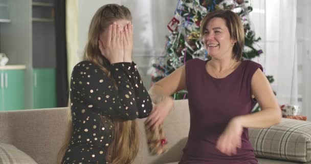 Γοητευτική μητέρα δίνει Χριστουγεννιάτικο δώρο στην ενήλικη κόρη της. Πορτρέτο της ευτυχισμένης οικογένειας γιορτάζει την παραμονή της Πρωτοχρονιάς στο σπίτι. Χαρούμενες γυναίκες γιορτάζουν σε εσωτερικούς χώρους. Κινηματογράφος 4k ProRes HQ. — Αρχείο Βίντεο