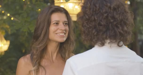 Portrait of smiling happy young woman hugging curly-haired boyfriend and smiling. Beautiful charming Caucasian girlfriend dating with elegant man in summer evening outdoors. Cinema 4k ProRes HQ. — Stock Video