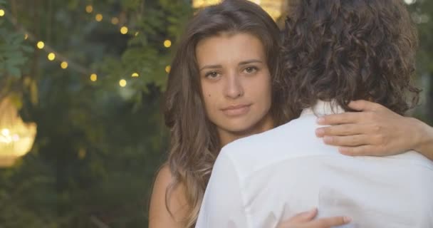 Close-up of cheating beautiful woman holding finger at lips as hugging man in summer evening outdoors. Portrait of Caucasian girlfriend having secret or preparing surprise. Cinema 4k ProRes HQ. — Stock Video