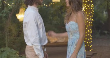 Yaz akşamında erkek gömleği ilikleyen tanınmamış genç, zayıf bir kadın. Açık havada çıkan mutlu beyaz çiftin yan görüntüsü. Aşk ve aşk kavramı. Sinema 4k ProRes Merkezi.