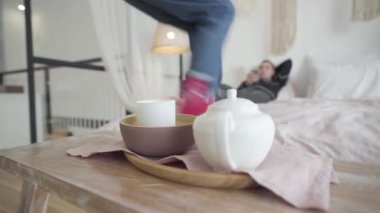 Genç ve neşeli bir kadın, yalan söyleyen bir adamla yatağa atlıyor. Neşeli beyaz çift Noel arifesinde eğleniyor. Masanın önünde duran çaya odaklanmış. Yeni yıl tatilleri sezonu.