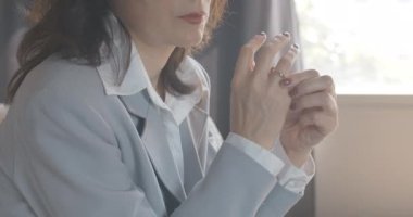 Tanımlanamayan, orta yaşlı beyaz bir kadının parmağından alyansı çıkardığı yakın plan. Üzgün kadın boşanmaya karar veriyor. Ayrılma konsepti. Sinema 4k ProRes Merkezi.