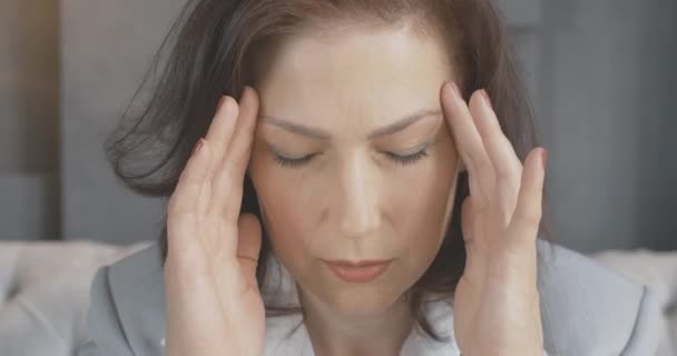 Kafkasyalı orta yaşlı bir kadının şiddetli baş ağrısı olan yakın plan portresi. Migreni olan üzgün, stresli kadın kameraya bakıyor. Esmer, yaşlanma sorunları olan güzel bir kadın. Sinema 4k ProRes Merkezi. — Stok video
