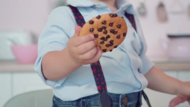 Close-up kue manis di tangan cabe kecil. Anak Kaukasia lucu yang tak dikenal memegang pencuci mulut. Konsep masa kecil. — Stok Video