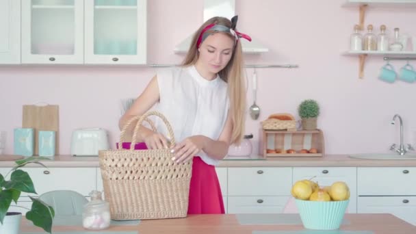 Jonge zelfverzekerde blanke vrouw die de keuken betreedt met aankopen. Portret van een mooie huisvrouw die terugkeert van de winkel met kookingrediënten. Huishouding en culinair concept. — Stockvideo