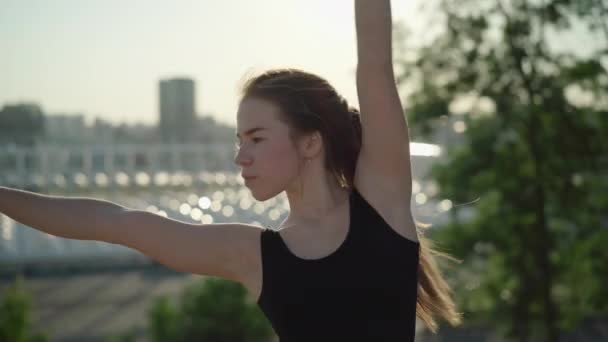 Live camera volgt beweging van slanke mooie blanke vrouw. Close-up portret van lachende brunette gymnaste bewegende handen in zonnestralen en kijken naar de camera. — Stockvideo