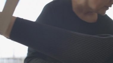 Kamera, kişisel antrenörüyle birlikte zayıf, genç, beyaz kadın vücudunda hareket ediyor. Tanımlanamayan beyaz kadın spor salonunda pilates yapıyor..