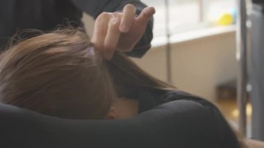 Canlı kamera, beyaz kadın sporcunun spor salonundaki hareketlerini izliyor. Zayıf, güzel bir kadın ve tanınmayan bir eğitmenin kişisel pilates eğitimi..