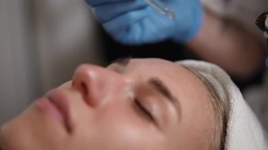 Odaklanmış cilt bakımı seansı, genç bir kadının yüz bakımı gördüğünü gösteriyor.