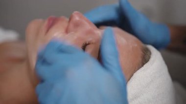 Huzurlu ve huzurlu bir spa ortamında yapılan rahatlatıcı bir yüz tedavisinin yakından görüntüsü