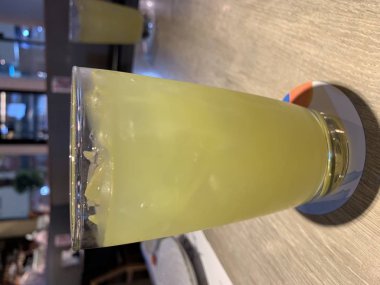 Ahşap bir masa üzerinde bir bardak buz yeşilçay