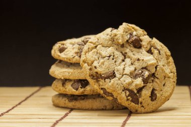 Çikolatalı kurabiye yığını siyah arka plan ile ahşap.