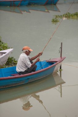 Pokhara, Nepal - 11 Eylül 2015: kimliği belirsiz kişi üzerinde 11 Eylül 2015 yılında Pokhara, Nepal fewa gölde balık tutma. Her sabah Nepal balıkçı gel göl balıkçılık için.