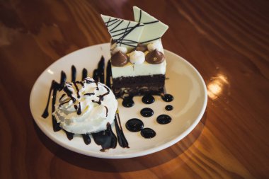 Beyaz bir tabakta çikolatalı kek ve krem şanti.