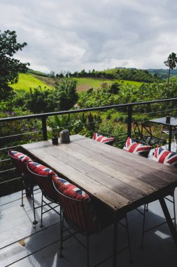 Manzara arka plan ile terasta sandalye ve masa.