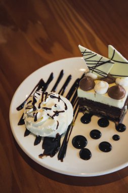 Beyaz bir tabakta çikolatalı kek ve krem şanti.