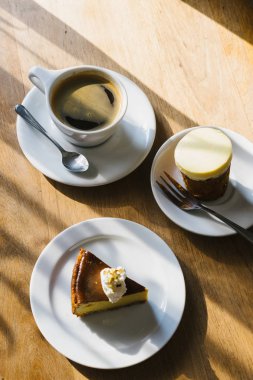 Öğleden sonra ışık ile ahşap masada kahve fincanı ve kabak pasta.