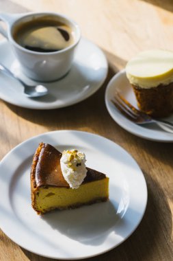 Öğleden sonra ışık ile ahşap masada kahve fincanı ve kabak pasta.