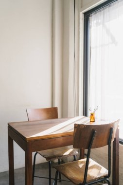 Boş kahve kafe, Thw ahşap masa ve sandalyeler güneş ışığı ile pencerenin yakın koymak.