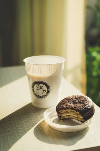 Sabah güneş ışığı ile ahşap masada Kahve fincanı ve choco pasta.