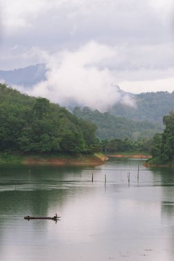 Balıkçı ve küçük balıkçı teknesi ve Bang Lang rezervuar yüzen.
