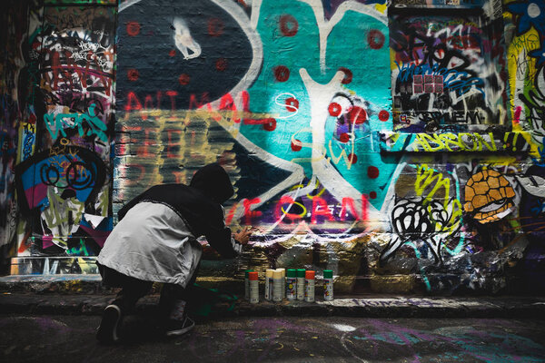 Melbourne, Australia - Nov 10, 2018 : Graffiti artist painting the wall on Hosier Lane on November 10, 2018.