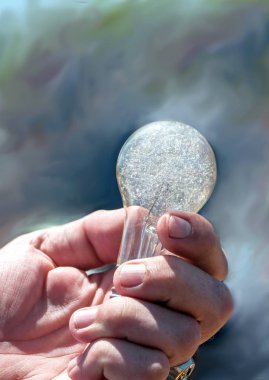 bir eski, antik flaş ampul geçmişten gelen flash fotoğrafçılıkta kullanılan cam, crackled ile bir adamın elini tutar