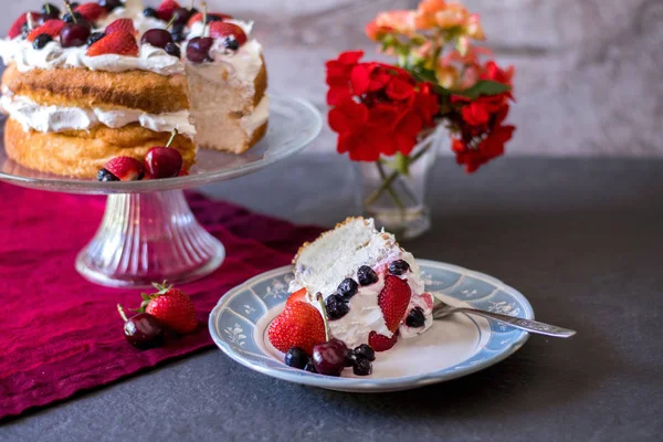 Angelcığım kek güzel bir dilim çırpılmış krema ve taze renkli meyveleri, çiçek ve meyve ile kaplı