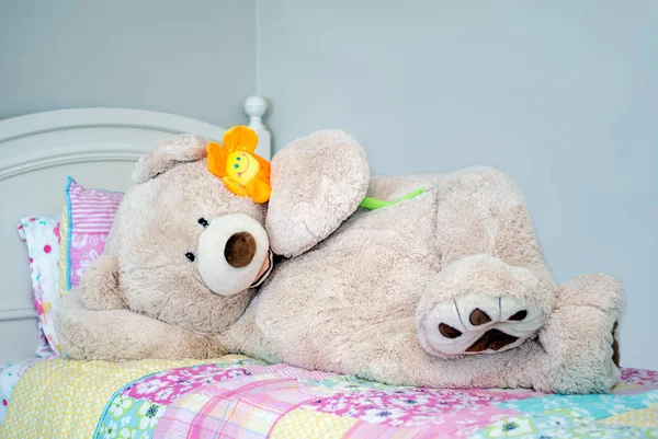 A large stuffed bear poses in his \'bare suit\' on a bed in this comical photo