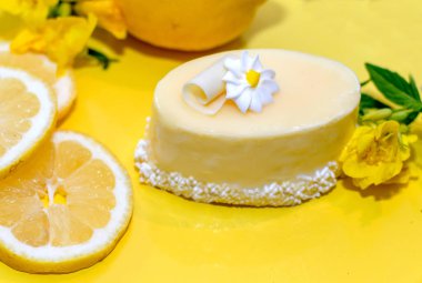 Küçük, güzel sırlı limon kek bir beyaz çikolata curl ve buzlanma çiçek