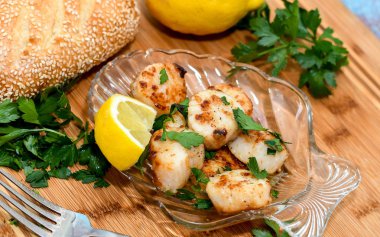 Maydanoz ve limon dilimi ile süslenmiş bir kabuk tabakta güzel kurutulmuş tarak