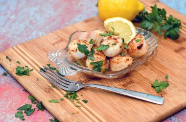 Sarımsak limon tereyağı soslu kurutulmuş tarak ile dolu cam kabuk levha