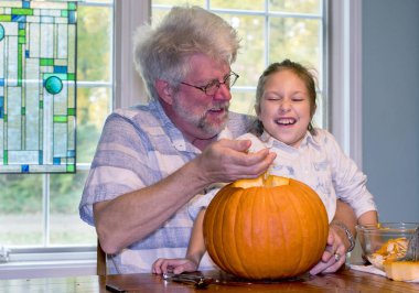 Dedem onu Cadılar Bayramı için oyma jack o fener sümüklü içi ile dalga geçiyor gibi küçük bir kız güler