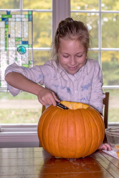 Liten Flicka Ler Som Hon Skopor Insidan Pumpa Till Halloween — Stockfoto