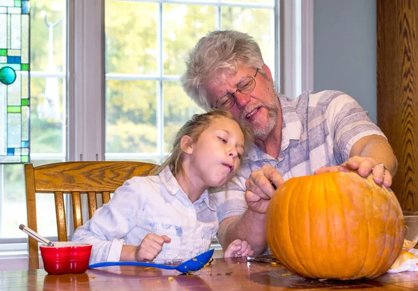 bir çocuk onun büyükbaba bir yüz balkabağına kesme saatler