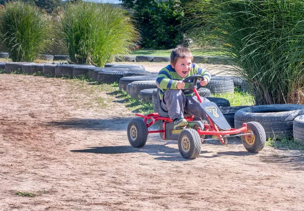 幸せな小さな男の子が車のペダルに少しスピード レーサーです — ストック写真