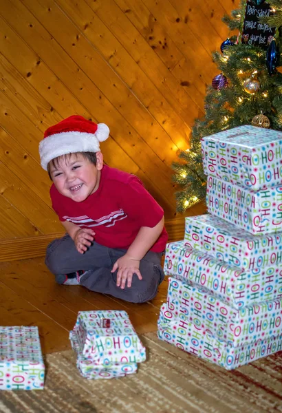 Laughing boy with stack of Christmas presents — Stock Photo, Image