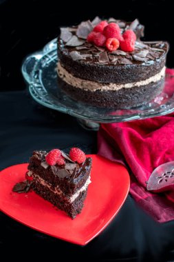 lezzetli çikolatalı kek havai görünümü, kırmızı bir bez ve kırmızı bir tabak ile koyu bir arka zemin karşı görüntülenen