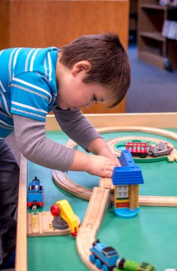 küçük çocuk trenler ile el ele oynuyor