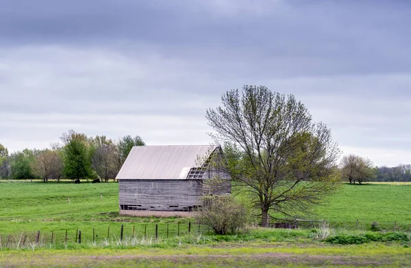 vintage barn falling apart in a field