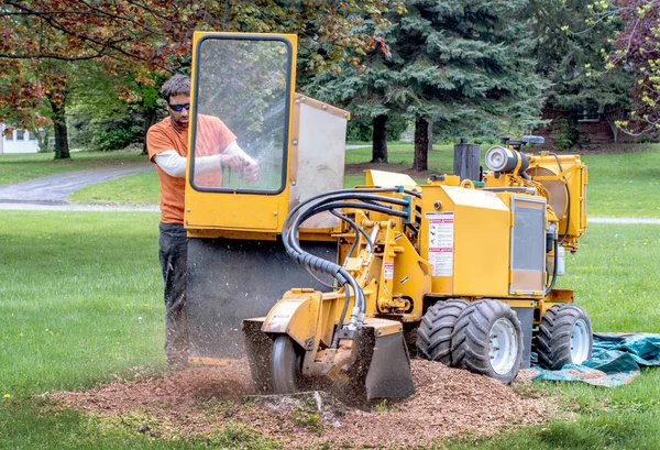 Man operates a stump grinder in a yard — Stock Photo, Image