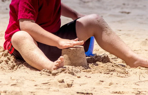 Niño construyendo un castillo de arena en la playa —  Fotos de Stock