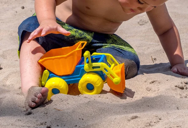 Niño juega con juguete de arena en la playa — Foto de Stock