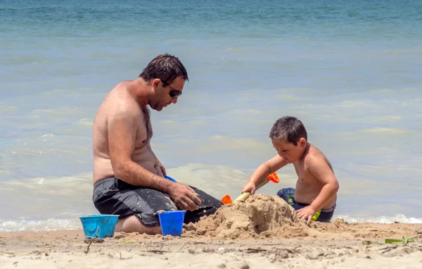 Papa baut mit Sohn eine Sandburg — Stockfoto